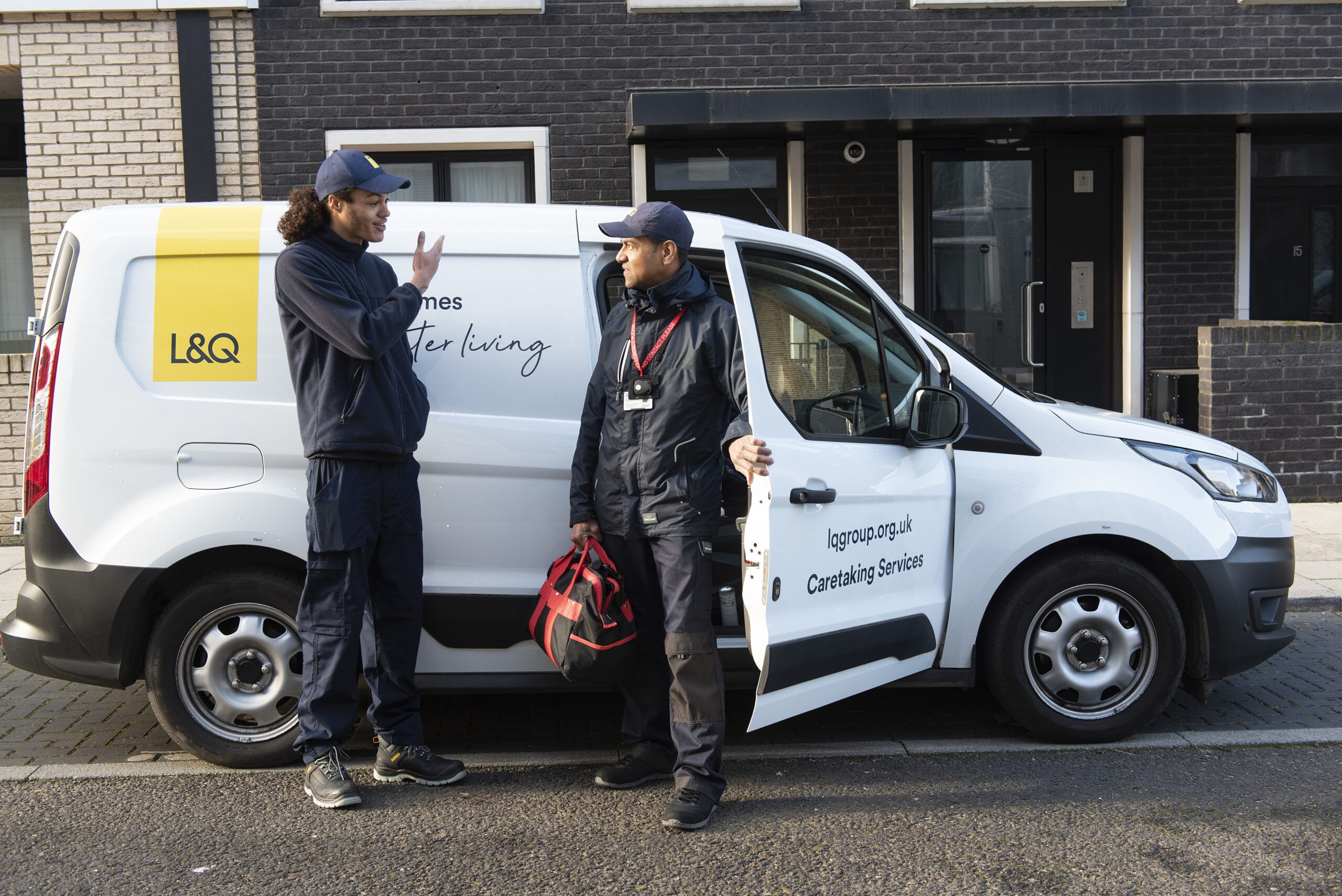 two men talking outside a van